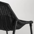 Close-up of the black woven rattan seat and black powder-coated steel leg on the Blu Dot Hint Chair