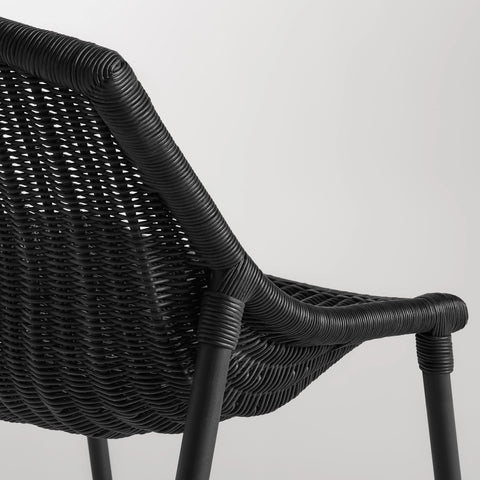 Close-up of the black woven rattan seat and black powder-coated steel leg on the Blu Dot Hint Chair
