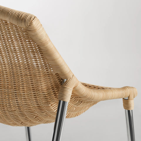 Close-up of the natural woven rattan seat and stainless steel leg on the Blu Dot Hint Chair