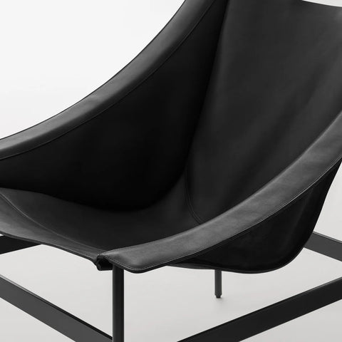 Detail view of the Blu Dot Heyday Lounge Chair in black leather with black steel frame showing the curved sling seat