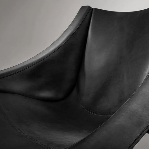 Close-up detail of the Blu Dot Heyday Lounge Chair in black leather showing the draped sling and stitching