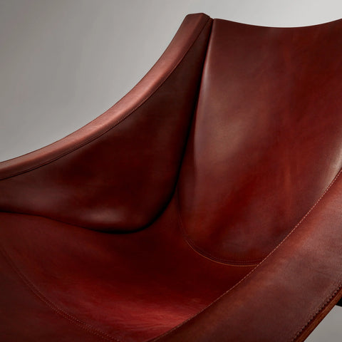 Close-up detail of the Blu Dot Heyday Lounge Chair showing the stitched seams and rich chestnut leather sling