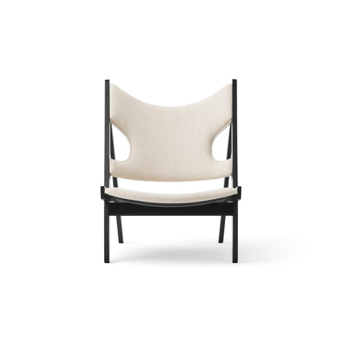Front view of the upholstered Knitting Lounge Chair by Audo Copenhagen with sculptural cut-out backrest.