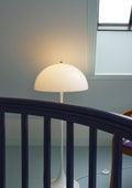 Louis Poulsen Panthella 400 Floor Lamp, white opal acrylic floor lamp, lit behind a dark wooden stair railing