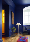 Louis Poulsen Panthella 400 Floor Lamp, white opal acrylic floor lamp, lit in a deep blue room beside a window desk
