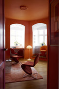 Louis Poulsen Panthella 400 Floor Lamp, white opal acrylic floor lamp, lit in an orange room with red lounge chairs