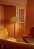 Louis Poulsen Panthella Floor Lamp, Original Opal Brown floor lamp, lit in the corner of an orange room beside a yellow sofa