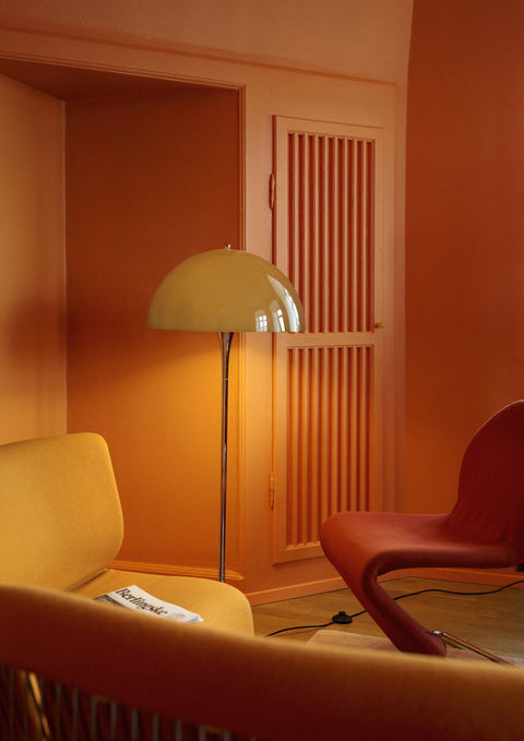 Louis Poulsen Panthella Floor Lamp, Original Opal Brown floor lamp, lit in the corner of an orange room beside a yellow sofa