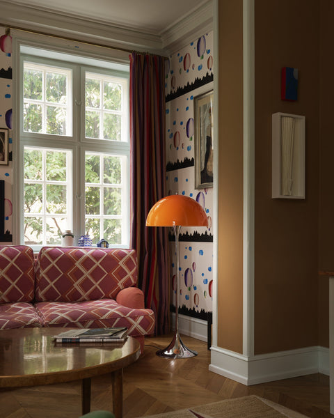 Louis Poulsen Panthella Floor Lamp, Original Opal Orange floor lamp by a window beside a pink patterned sofa