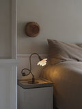Louis Poulsen PH 1/1 Piano Table Lamp, Limited Edition, lit on a bedside table beside a bed with grey linen
