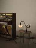 Louis Poulsen PH 1/1 Piano Table Lamp, Limited Edition, lit on a small side table beside an open upright piano and a microphone stand