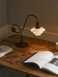 Louis Poulsen PH 1/1 Piano Table Lamp, Limited Edition, lit on a rustic wooden desk above an open book