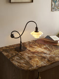 Louis Poulsen PH 1/1 Piano Table Lamp, Limited Edition, lit on a stone-topped wooden cabinet beside a stack of books