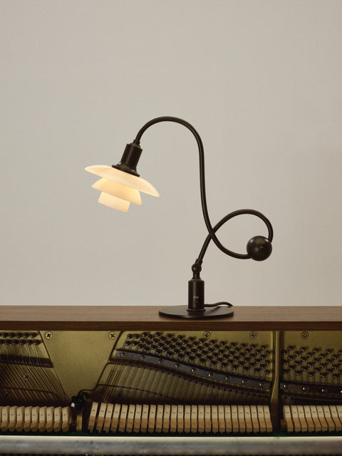 Louis Poulsen PH 1/1 Piano Table Lamp, Limited Edition, lit on top of an open upright piano with its hammers and strings on show