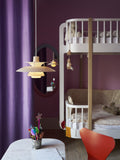 Louis Poulsen PH 5 Opal pendant light in Opal Beige, lit above a marble table and red chair in a children's room with purple curtains