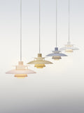 Four Louis Poulsen PH 5 Opal pendant lights in pale rose, beige, pale blue and white, lit and hung in a diagonal line on a pale grey backdrop