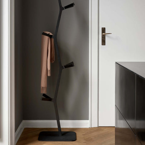 sculptural coat stand in black lacquered finish in an entryway designed by shin azumi for fredericia furniture