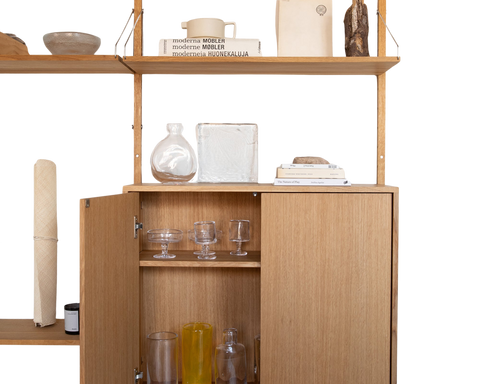 Frama Shelf Library Medium Cabinet Section in Natural Oak, cabinet with one door open showing glassware, ceramics and books on the shelf above