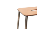 Frama Adam Stool, close up of the rounded leather seat corner, its slot handle and the raw steel legs joining underneath
