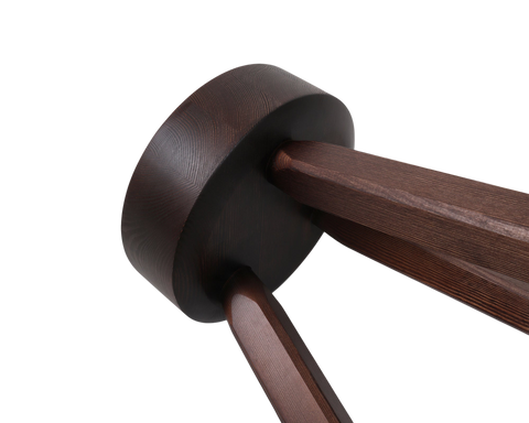 Frama AML Stool in Dark Pine, close up of the tapered legs meeting the underside of the thick round seat, wood grain visible