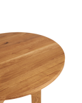 Frama Farmhouse Trestle Table in Natural Oak, crop of the round oak top showing the grain and the eased edge above a leg