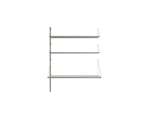 Frama Shelf Library Add-on Desk Section in Stainless Steel, one upright carrying two narrow steel shelves above a wider desk shelf, on white