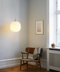 VL45 Radiohus Pendant hanging low in by a lounge chair, designed by Vilhelm Lauritzen for Louis Poulsen