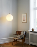 VL45 Radiohus Pendant hanging low in by a lounge chair, designed by Vilhelm Lauritzen for Louis Poulsen