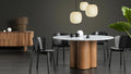 Blu Dot 4/4 Round Dining Table 60-inch with marble top and walnut base in a dark moody dining room

