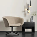 Blu Dot Dally Nightstand in black, styled in a modern interior beside a beige bouclé swivel lounge chair with stacked Blu Dot design books on the lower shelf and a chrome vase on top, with black and glass pendant lights in the background