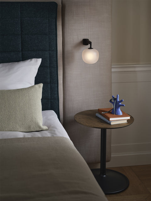 muuto soft side table in oiled smoked oak top and black base used as a bedside table