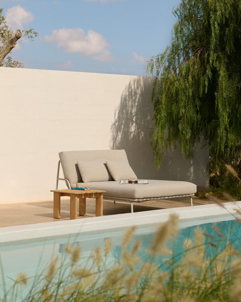 Muuto Settle Lounge Bed in laze grey with Assemble Coffee Table 55 cm in teak beside pool, outdoor lounge scene