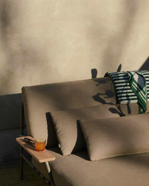 Muuto Settle Lounge Bed with Armrest in taupe fabric — Scandinavian minimalist outdoor furniture with wooden arm detail
