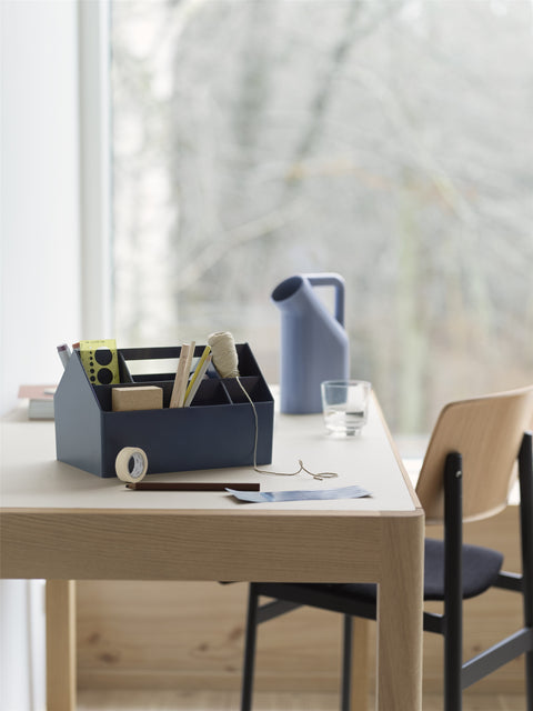 Minimalist Muuto Sketch Toolbox with office supplies on wooden desk