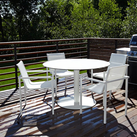 Skiff 47" Large Outdoor Café Table by Blu Dot in white, styled on outdoor deck with dining chairs