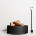 Smokey Fire Pit by Blu Dot in blackened steel, styled with firewood and Pokey von Pokerson Fire Poker