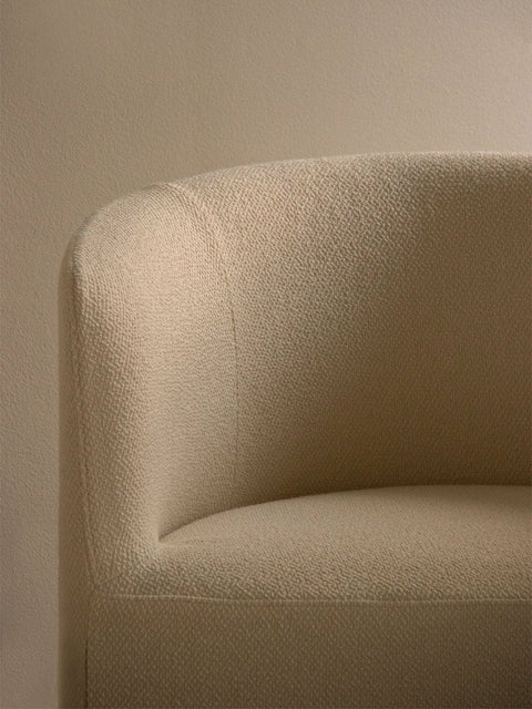 Audo Copenhagen Tearoom Chair, With Loose Cover, close-up of the Tearoom Lounge Chair's loose cover, showing the textured beige bouclé fabric on its curved back