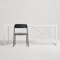 Trim Chair by Blu Dot in Black perforated powder-coated steel, front view with Strut dining table