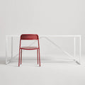 Trim Chair by Blu Dot in Carmine perforated powder-coated steel, front view with Strut dining table