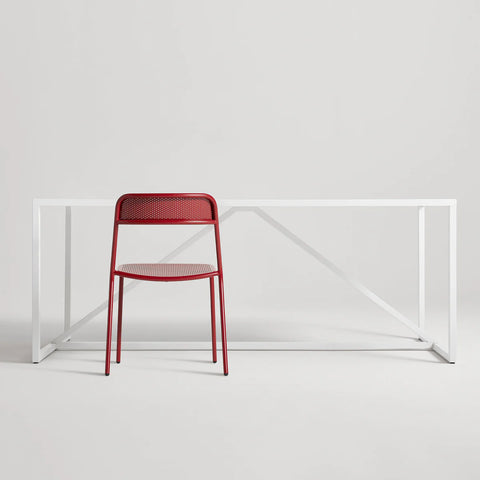 Trim Chair by Blu Dot in Carmine perforated powder-coated steel, front view with Strut dining table