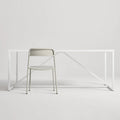 Trim Chair by Blu Dot in Putty perforated powder-coated steel, front view with Strut dining table