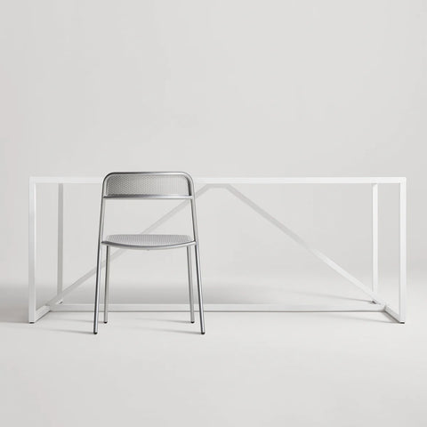 Trim Chair by Blu Dot in Silver perforated powder-coated steel, front view with Strut dining table