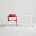 Trim Armchair by Blu Dot in Carmine perforated powder-coated steel, front view with Strut dining table
