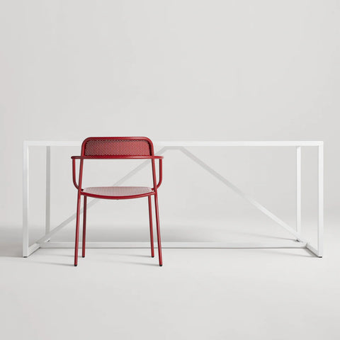 Trim Armchair by Blu Dot in Carmine perforated powder-coated steel, front view with Strut dining table