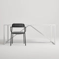 Trim Armchair by Blu Dot in Black perforated powder-coated steel, front view with Strut dining table