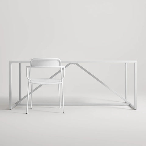 Trim Armchair by Blu Dot in White perforated powder-coated steel, front view with Strut dining table
