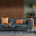 Blu Dot Bonnie 72" Sofa in slate blue velvet with warm accent pillows against a dark wood slat wall in a modern living room