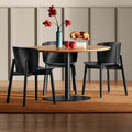 Blu Dot Buddy Chair in black on ash styled around a round pedestal dining table in a warm modern dining room