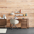 Blu Dot Dang File Pedestal in walnut veneer with antique brass pulls, styled in a modern home office beside a walnut desk, upholstered swivel task chair, and wall-mounted shelving against a wood plank wall