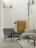 Close-up of Muuto Leaf Floor Lamp in a modern lounge with cozy seating.